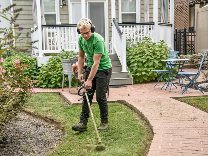 Landscaper trimming the lawn of a home