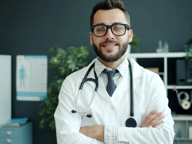 Smiling doctor in a white coat in his office